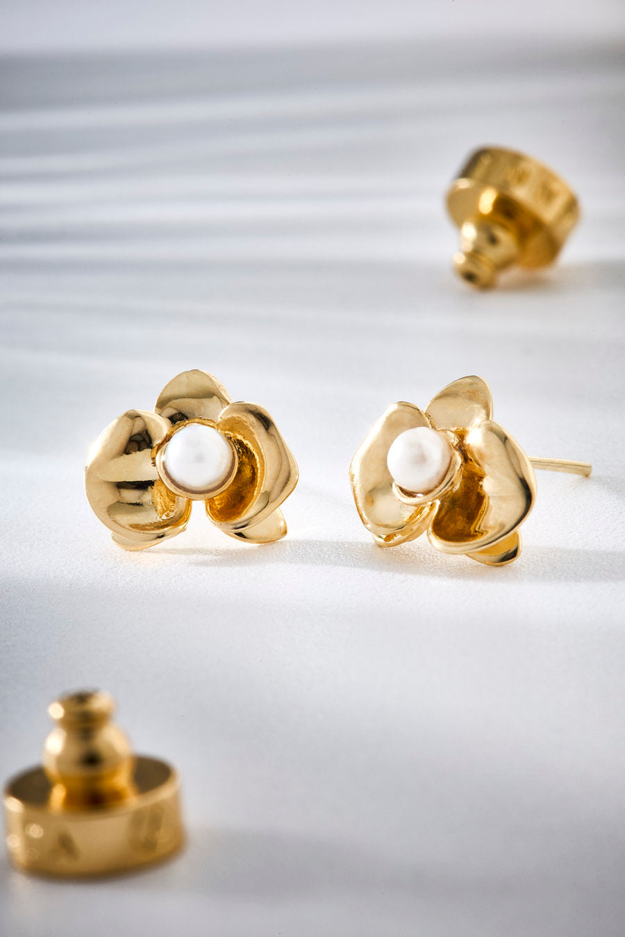 Brinco Florescer dourado inspirado na delicadeza dos vínculos que amadurecem no tempo, com forma floral suave e presença luminosa.