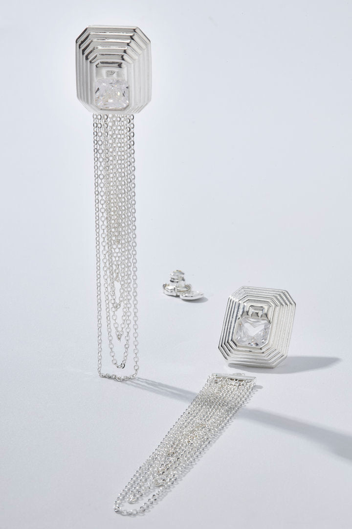 Brinco Lumier prata com design geométrico, zircônia central e franjas em corrente para looks elegantes, marcantes e sofisticados.