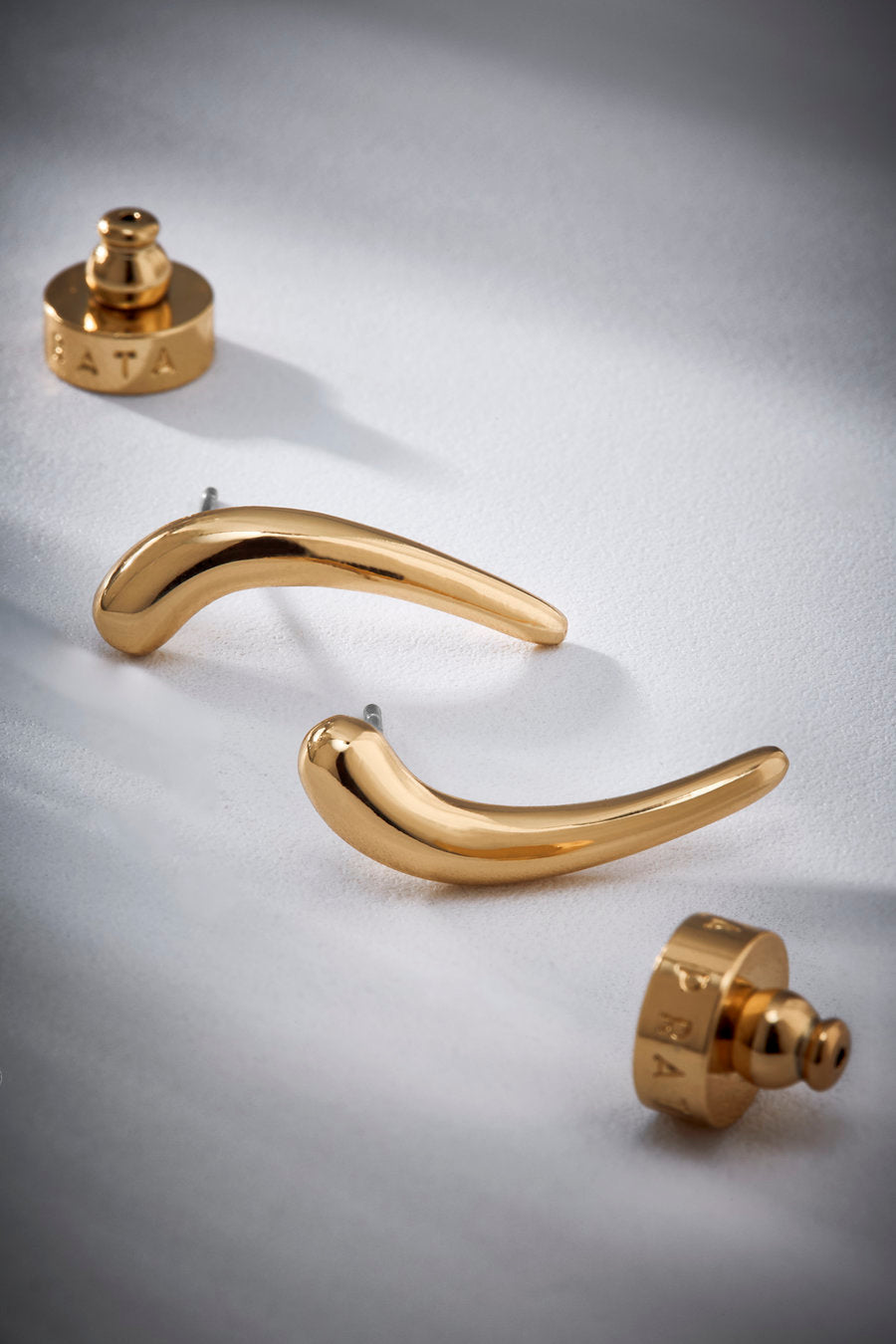 Brinco Passaggio P em metal nobre com banho ouro 18k – curva minimalista e acabamento polido