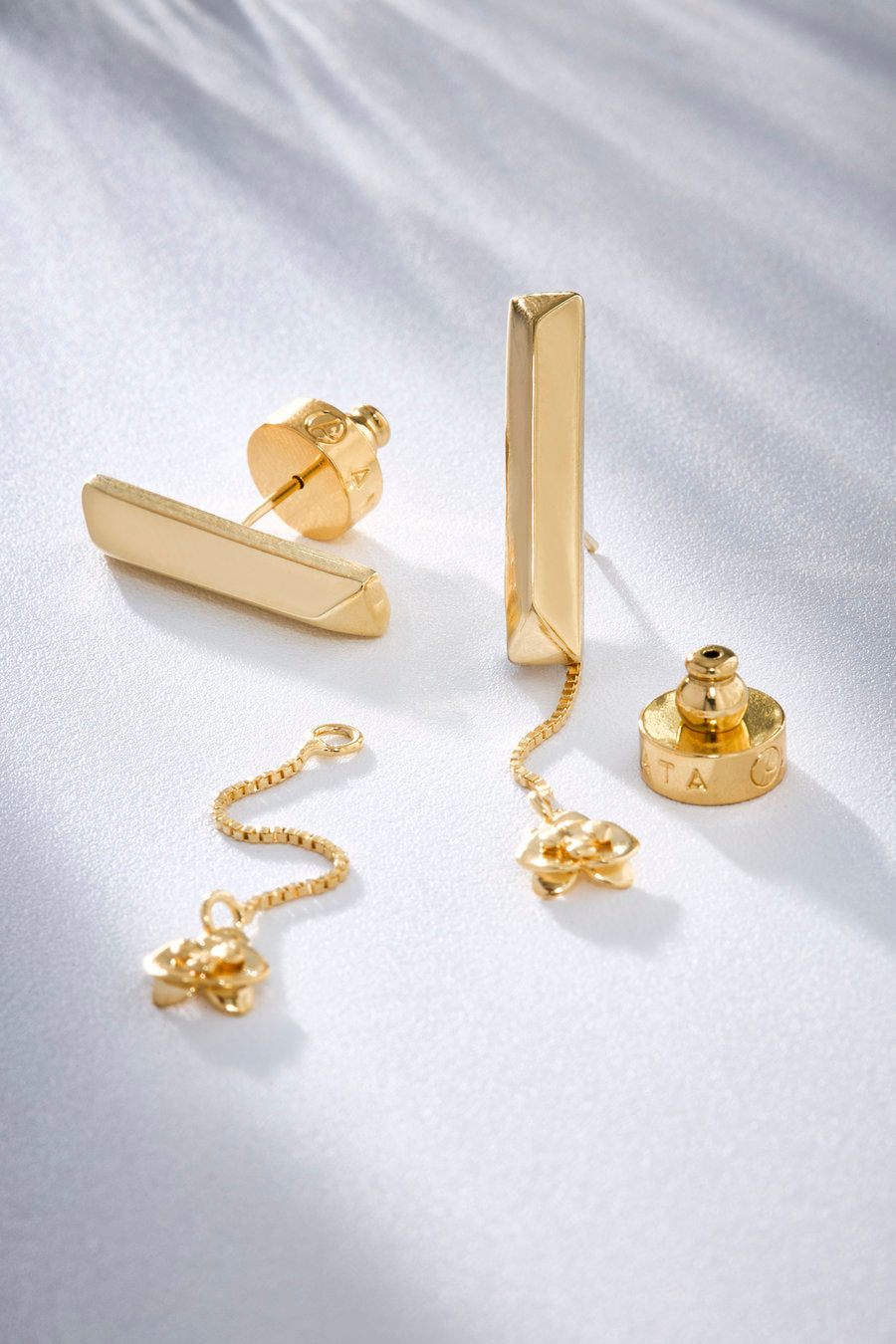 Brinco de linhas minimalistas e detalhe pendente, criado para trazer elegância contemporânea e leveza a produções sofisticadas do dia a dia.