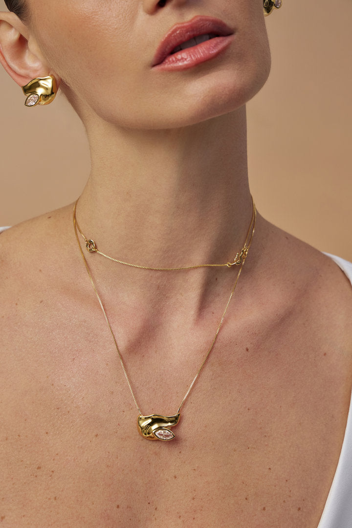 Colar dourado Elsa com corrente delicada, pingente assimétrico e cristal com lapidação exclusiva