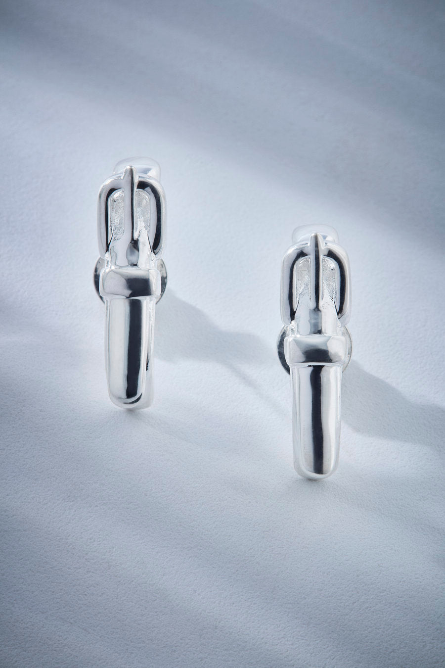 Earhook prata de design escultural, com linhas limpas e estrutura marcante. Uma joia contemporânea que combina força visual, sofisticação e versatilidade para composições elegantes e autorais.