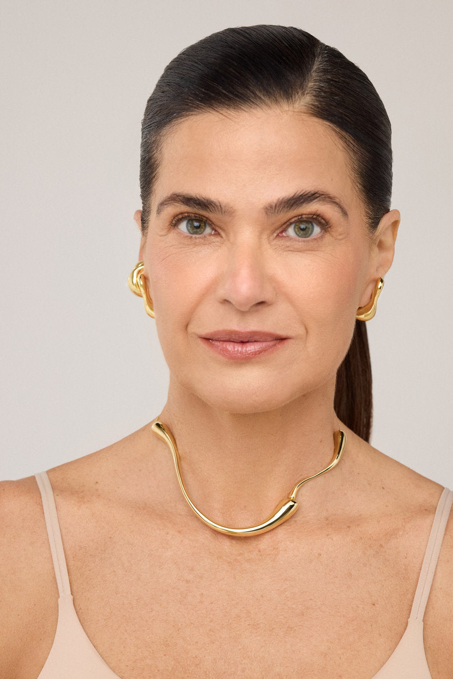 Gargantilha Memória dourada com design orgânico fluido e forma aberta