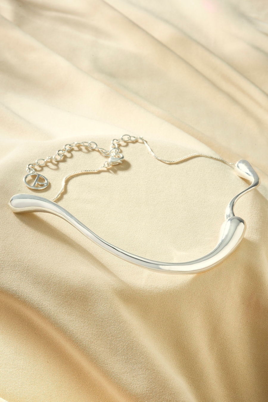 Gargantilha feminina dourada com design fluido elegante e contemporâneo