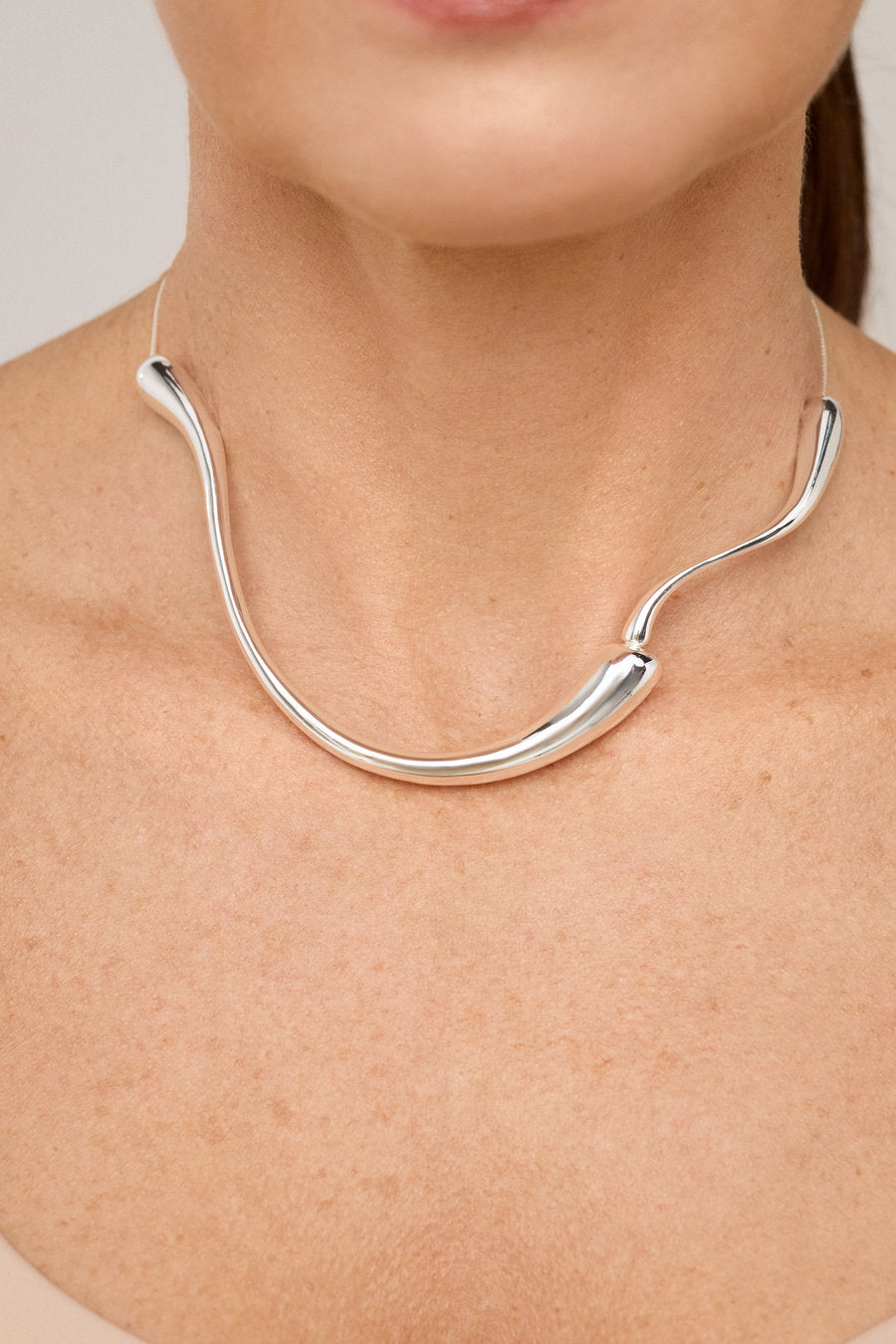 Colar gargantilha dourado com forma orgânica e acabamento polido