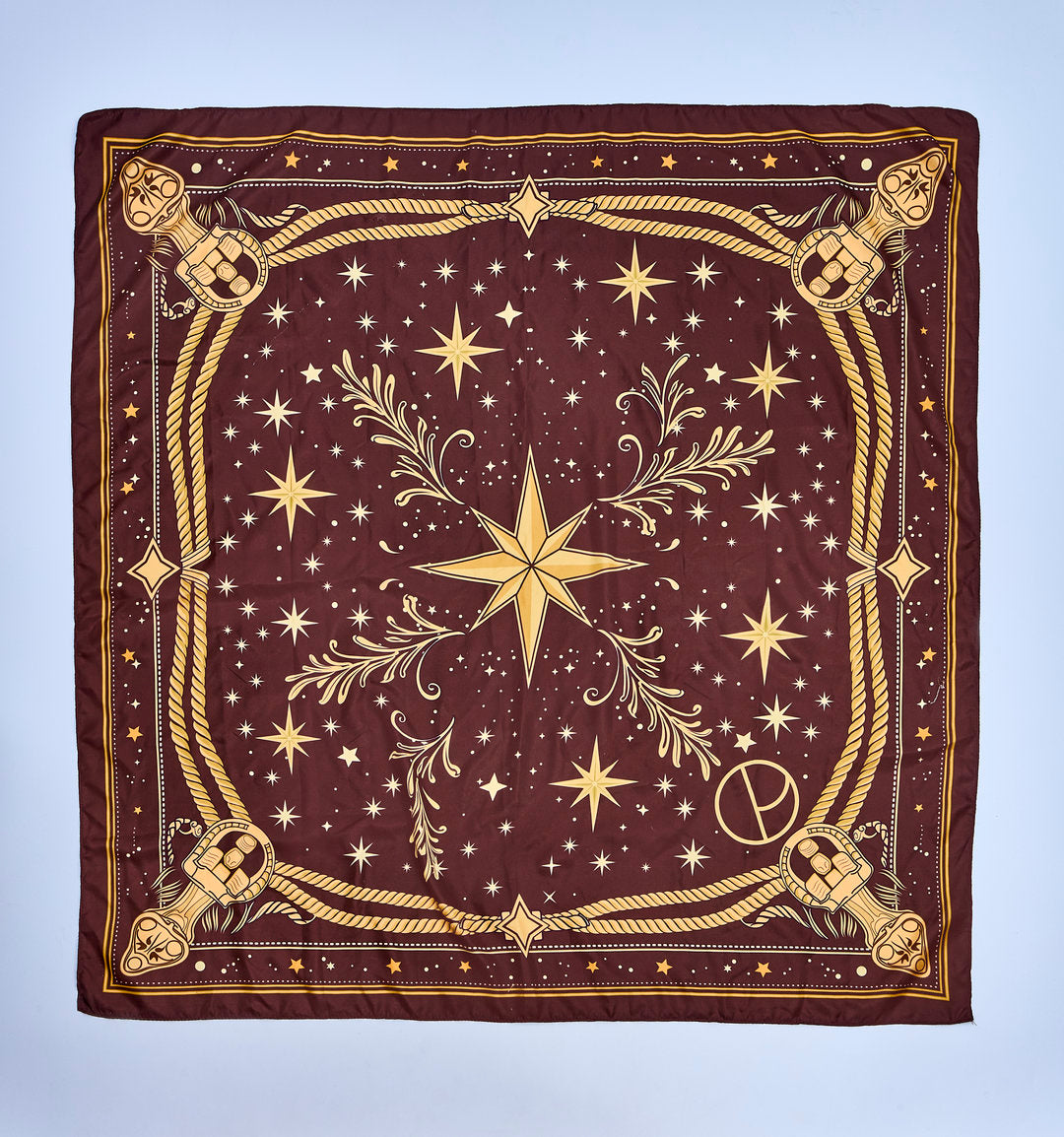 Lenço quadrado vinho com estampa dourada de estrelas, cordas ornamentais, arabescos e estrela central inspirada no universo celeste.
