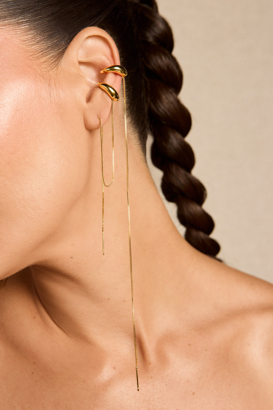 Piercing Delicata dourado – acessório de orelha com curvas sobrepostas e corrente fina