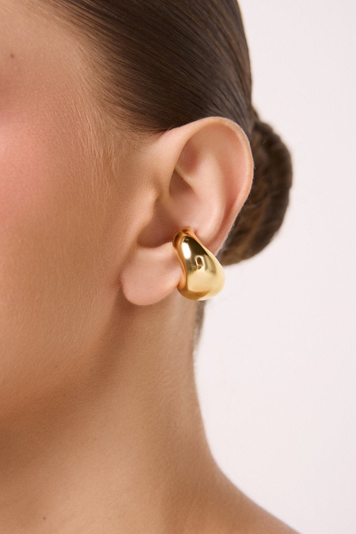 piercing dourado, piercing feminino, piercing de pressão, piercing orgânico, piercing escultural, piercing em gota, piercing moderno, piercing dourado, piercing sofisticado, ear cuff prateado, piercing de design autoral, joia dourada, piercing elegante, piercing para presente
