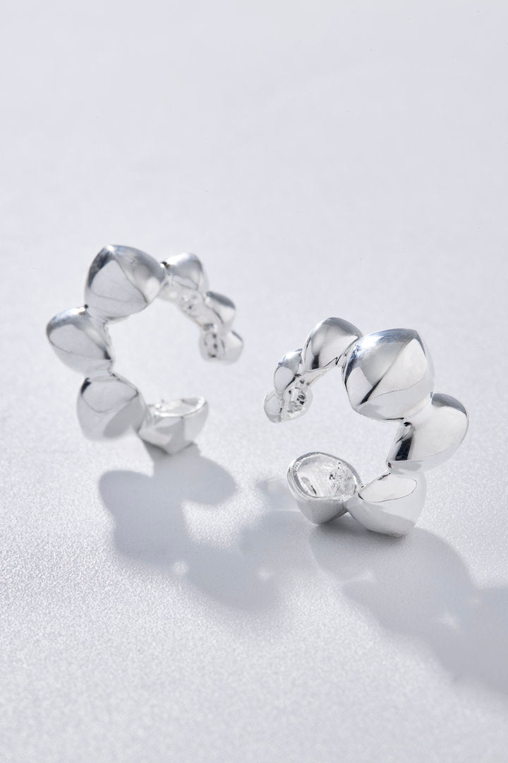 Piercing Trama prata com design volumoso de formas orgânicas sobrepostas.