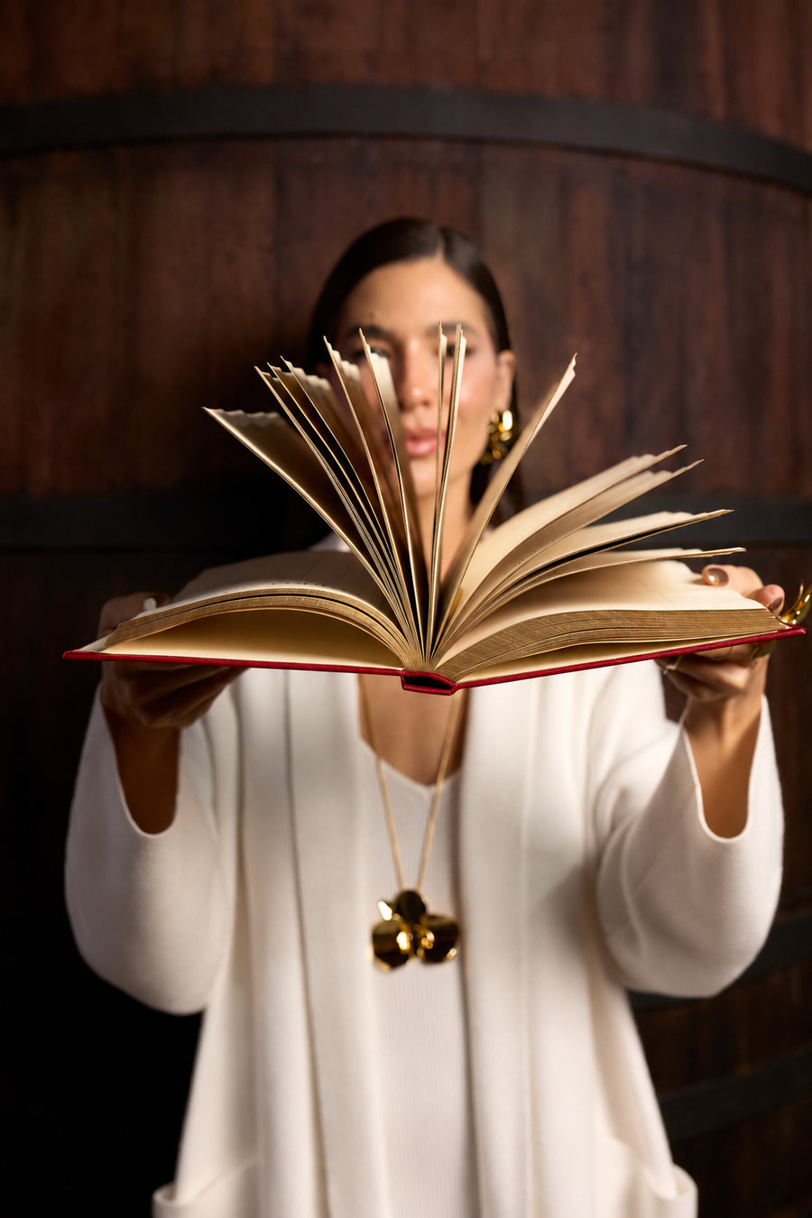 Anna Prata apresenta o Livro Vinho da Casa 2027 aberto, com páginas em movimento. Devocional cristão e planner anual para mulheres.
