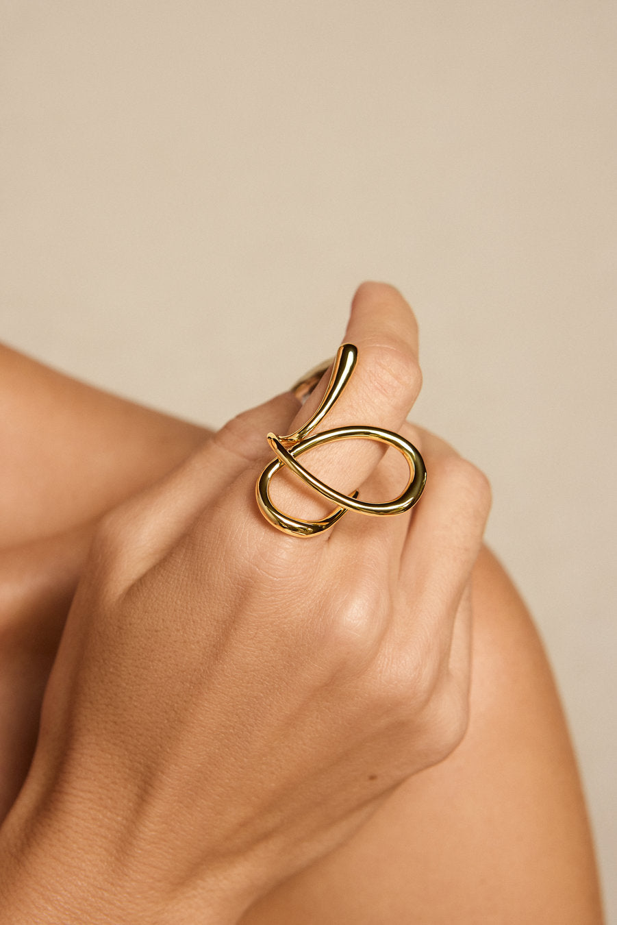 Anel Amparo dourado – anel contemporâneo com linhas fluidas e composição escultural