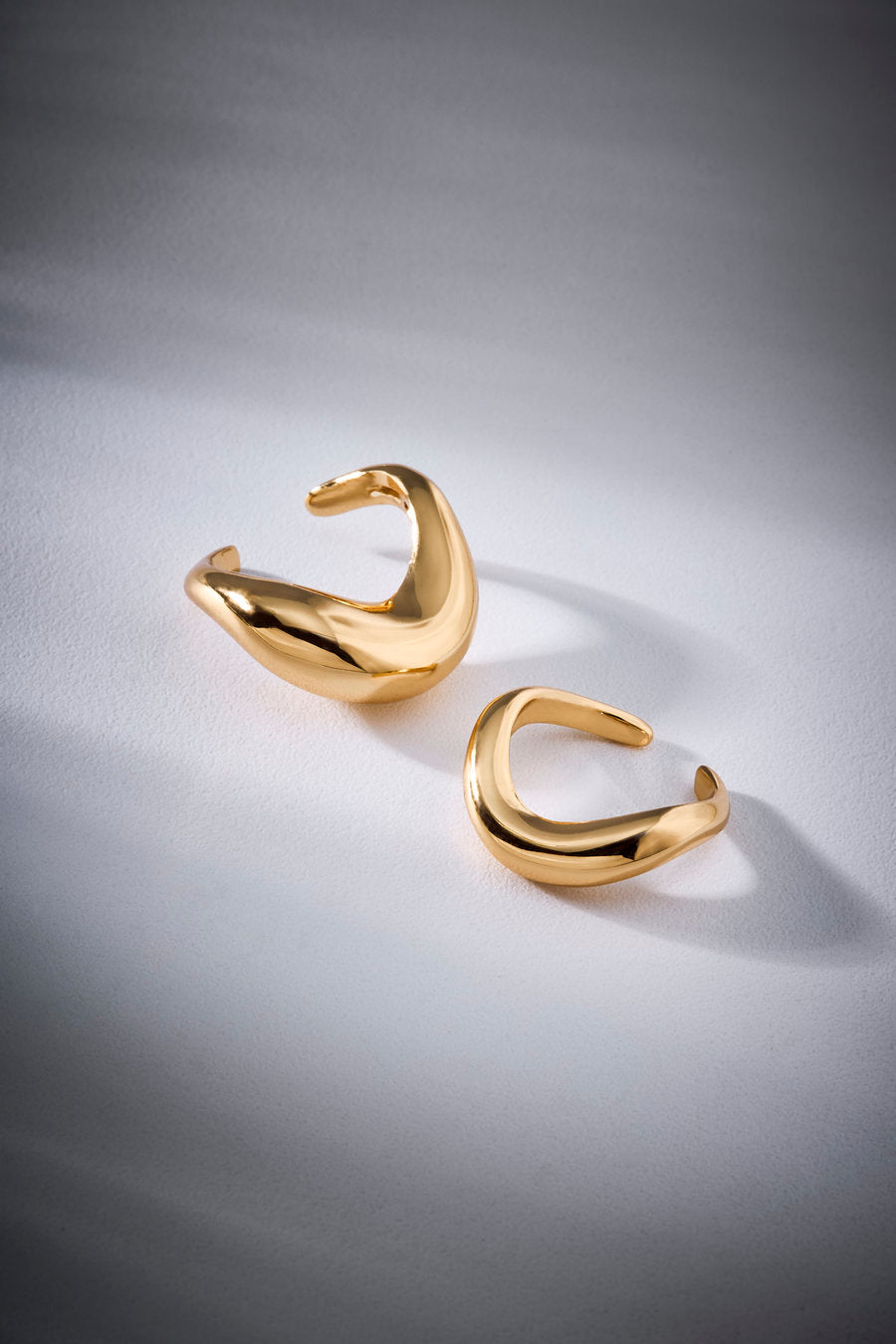 Anel Duplo Passaggio dourado – curvas orgânicas, design escultural e acabamento polido.