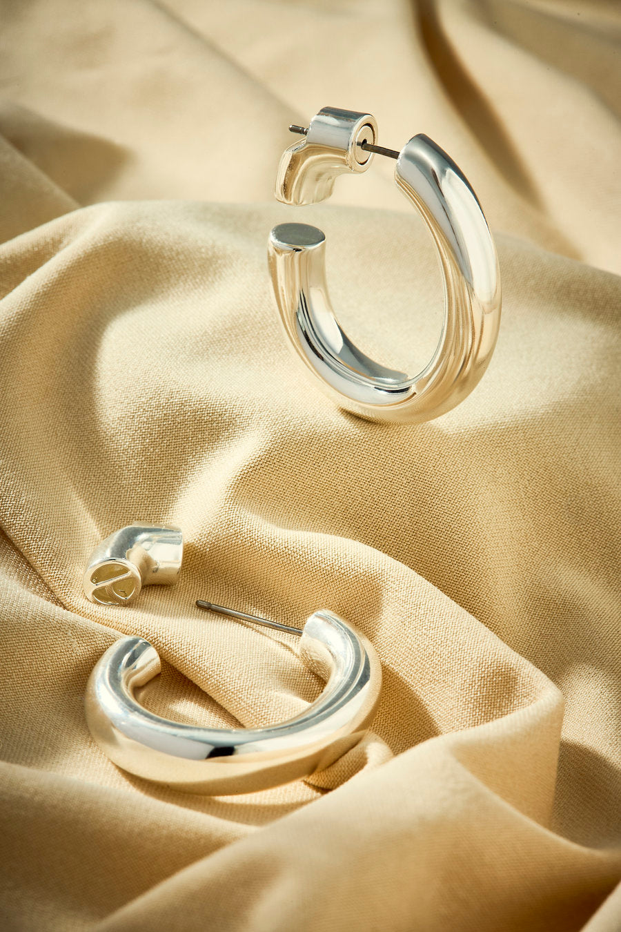 Argola feminina prata com curvas suaves e elegância minimalista