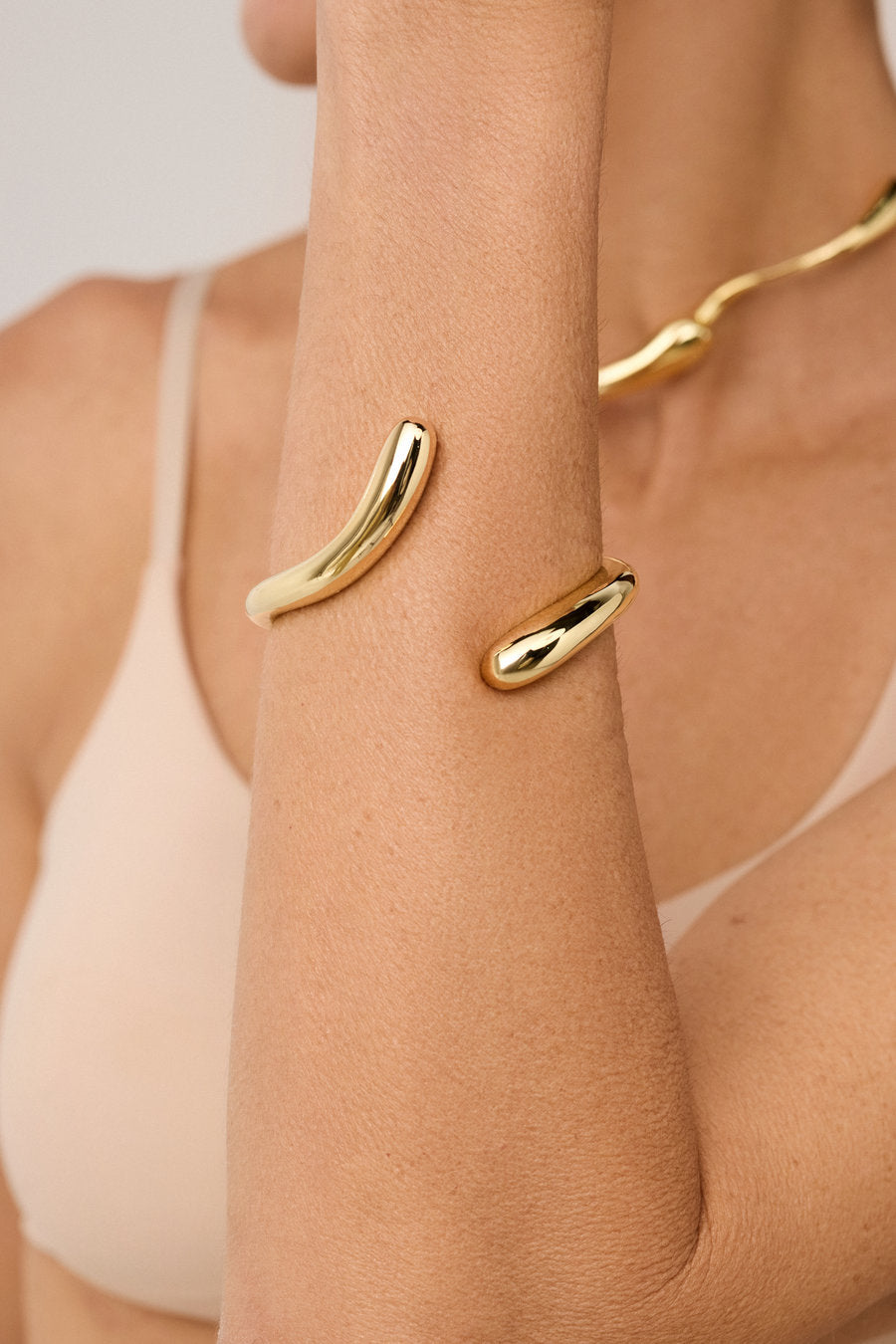 Bracelete Memória dourado com design orgânico fluido e forma aberta