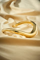 Bracelete autoral dourado com curva fluida e estética minimalista e visual  elegante
