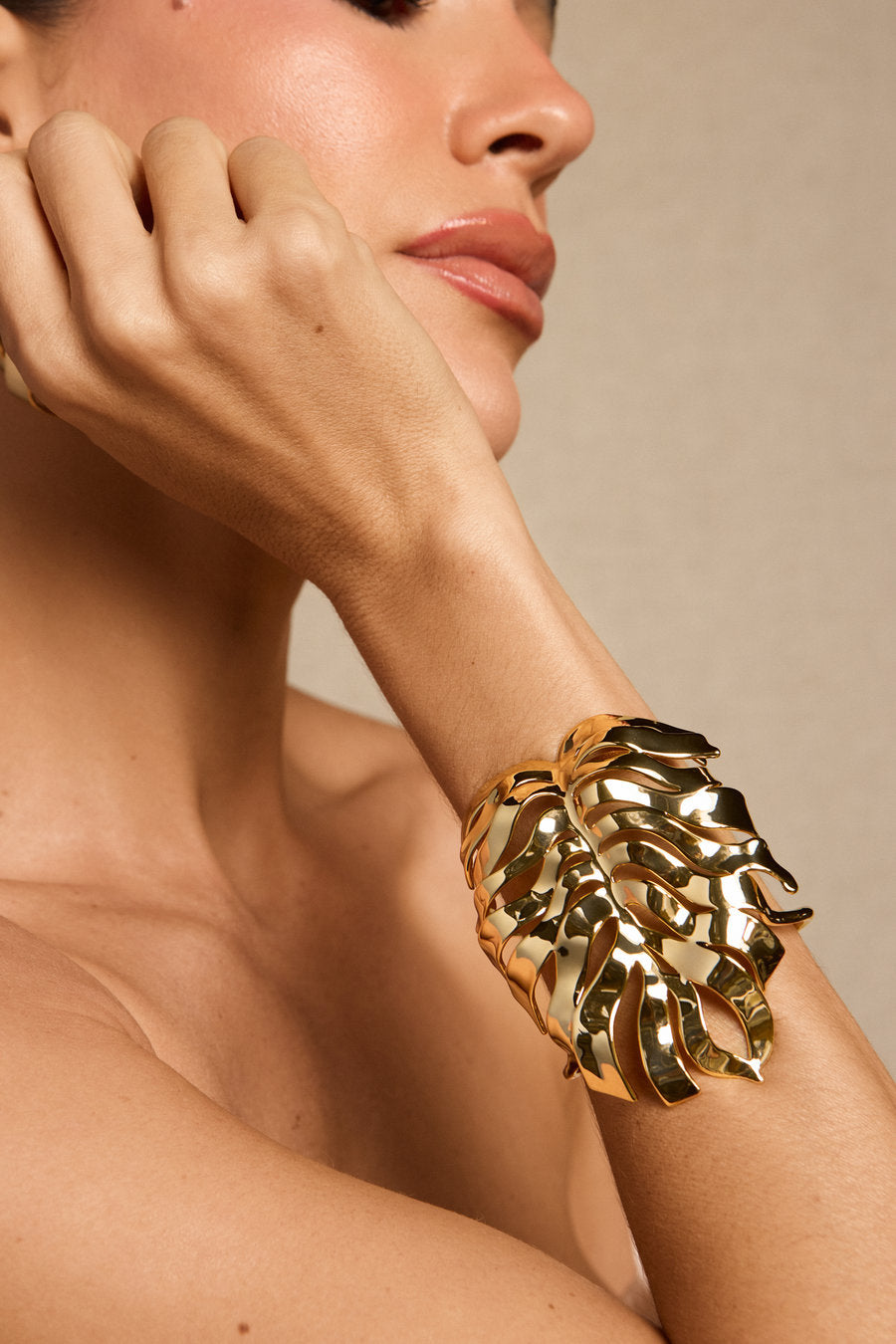 Bracelete Renascer dourado – bracelete largo com folha vazada, curvas orgânicas e acabamento polido