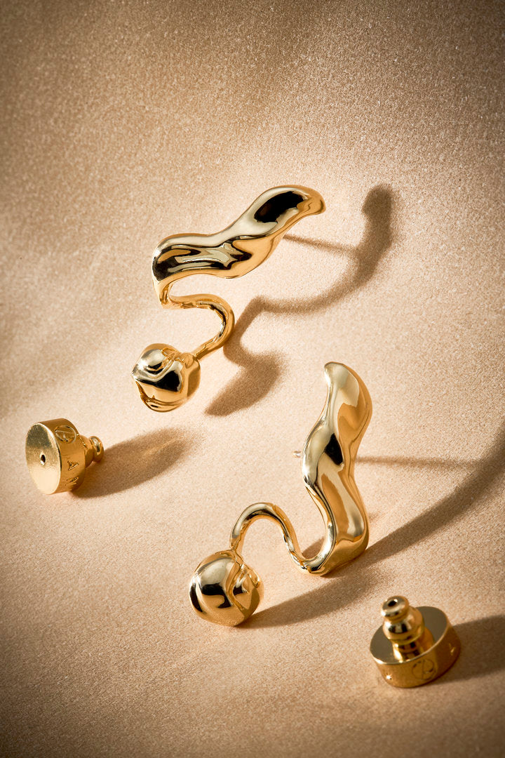 Brinco Frida dourado com formas fluidas, joia statement para produções elegantes.