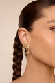 Brinco statement dourado, design escultural, ideal para produções sofisticadas e marcantes.
