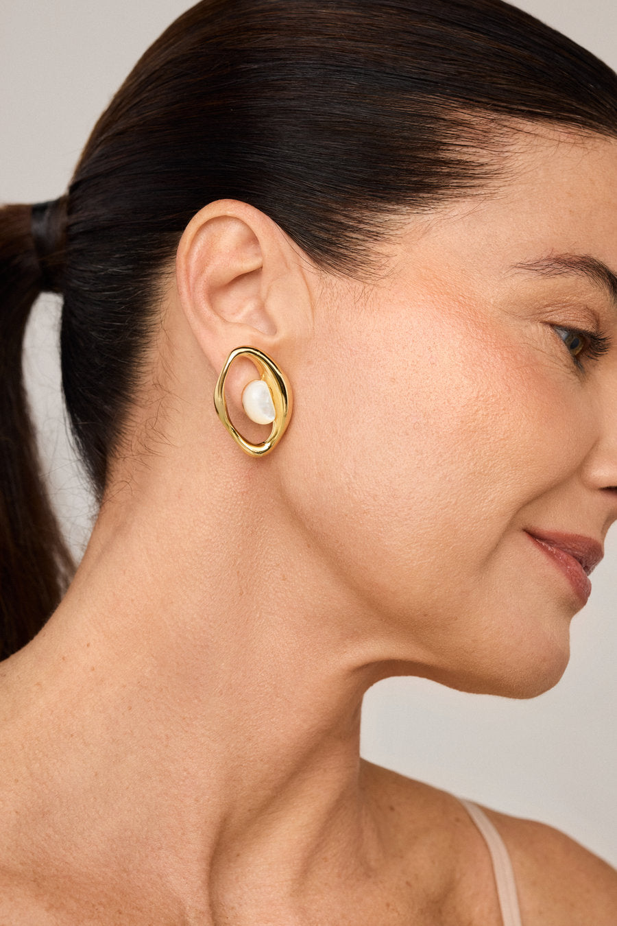 Brinco Presente dourado com madrepérola e design escultural orgânico