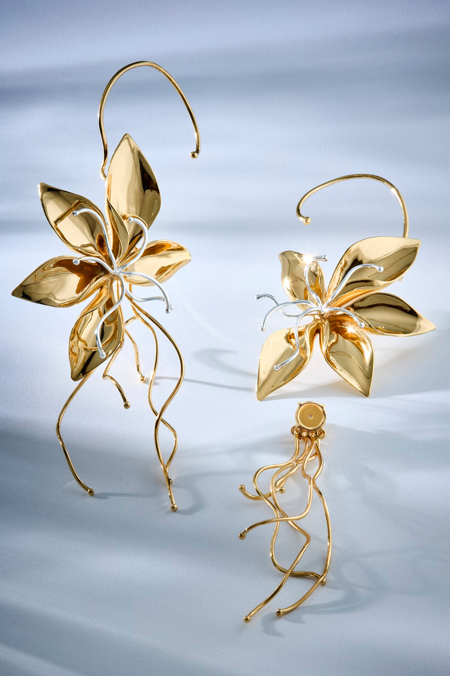 Brinco Renascer dourado – design floral escultural com pétalas, folhas e fios alongados em movimento