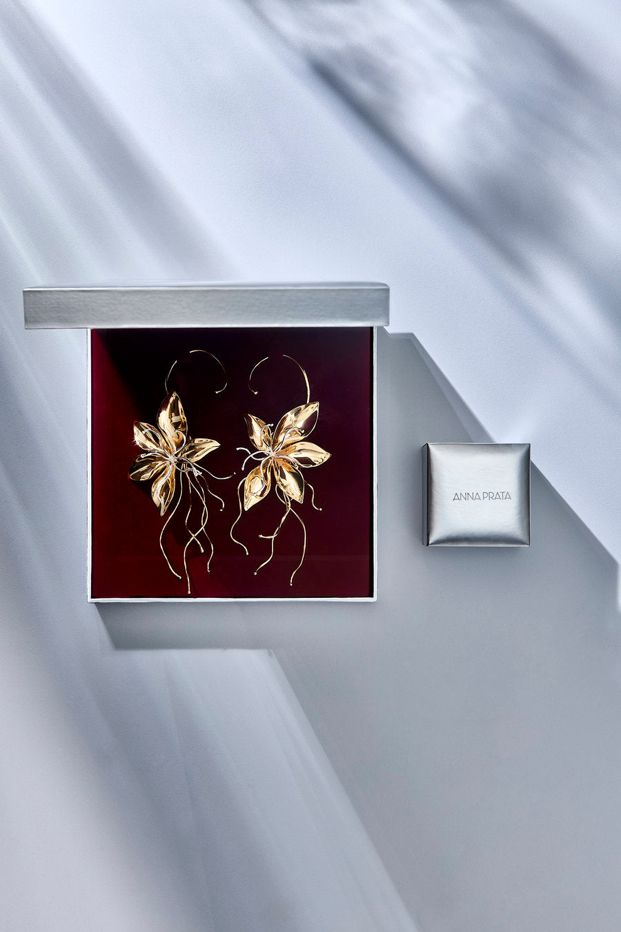 Brinco Renascer dourado – brinco floral statement com pétalas volumosas e detalhes prateados. Acompanha uma caixa de presente personalizada.