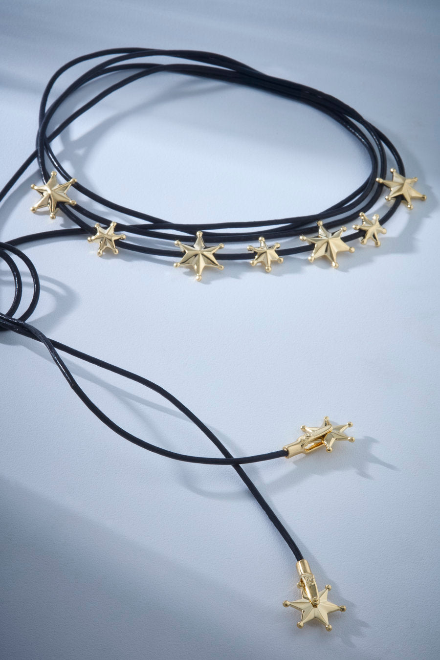 Colar de cordões marrons com estrelas douradas que combina linguagem celeste e visual contemporâneo. Uma peça marcante, leve e versátil, ideal para composições modernas com personalidade e presença.