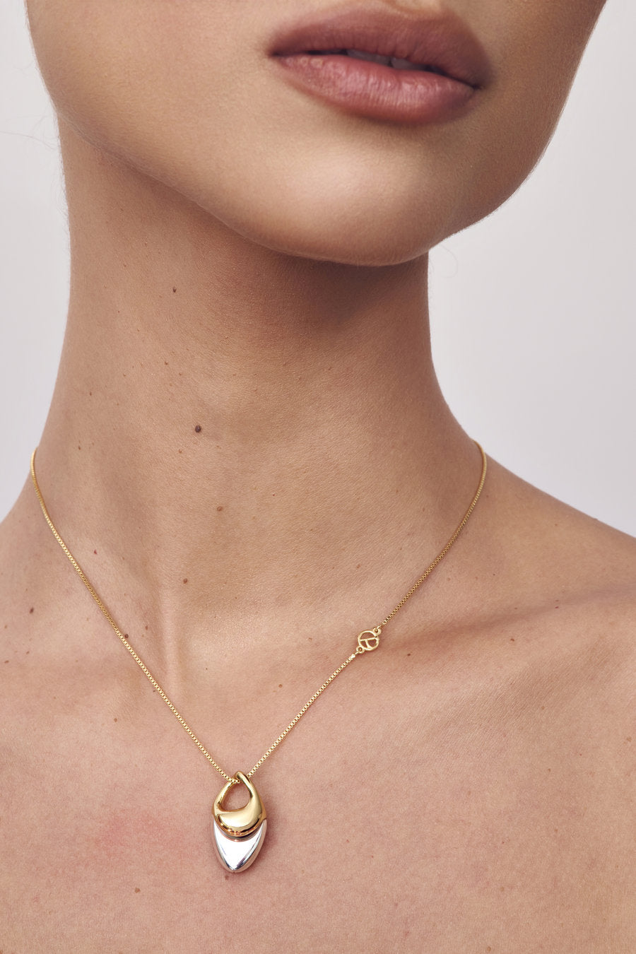 Colar Fluire bimetal dourado e prata – pingente orgânico com curvas fluidas – design contemporâneo