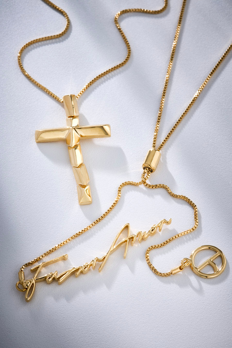 Colar Redenção dourado com cruz escultural que simboliza amor absoluto, entrega e o vínculo profundo entre fé, sacrifício e devoção materna.