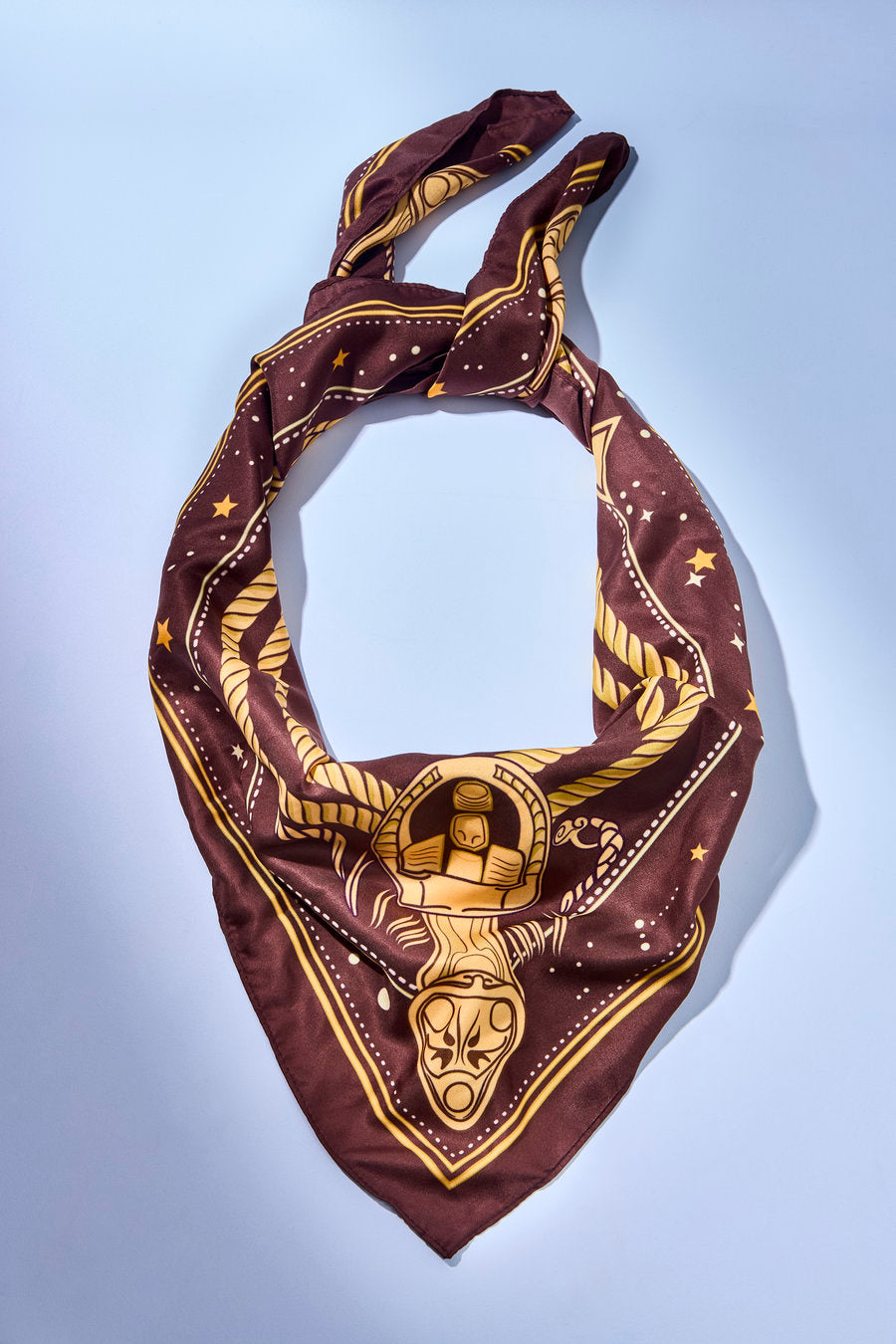 Lenço Destino vinho com estampa celestial em dourado, ideal para compor looks elegantes no pescoço, cabelo ou bolsa.
