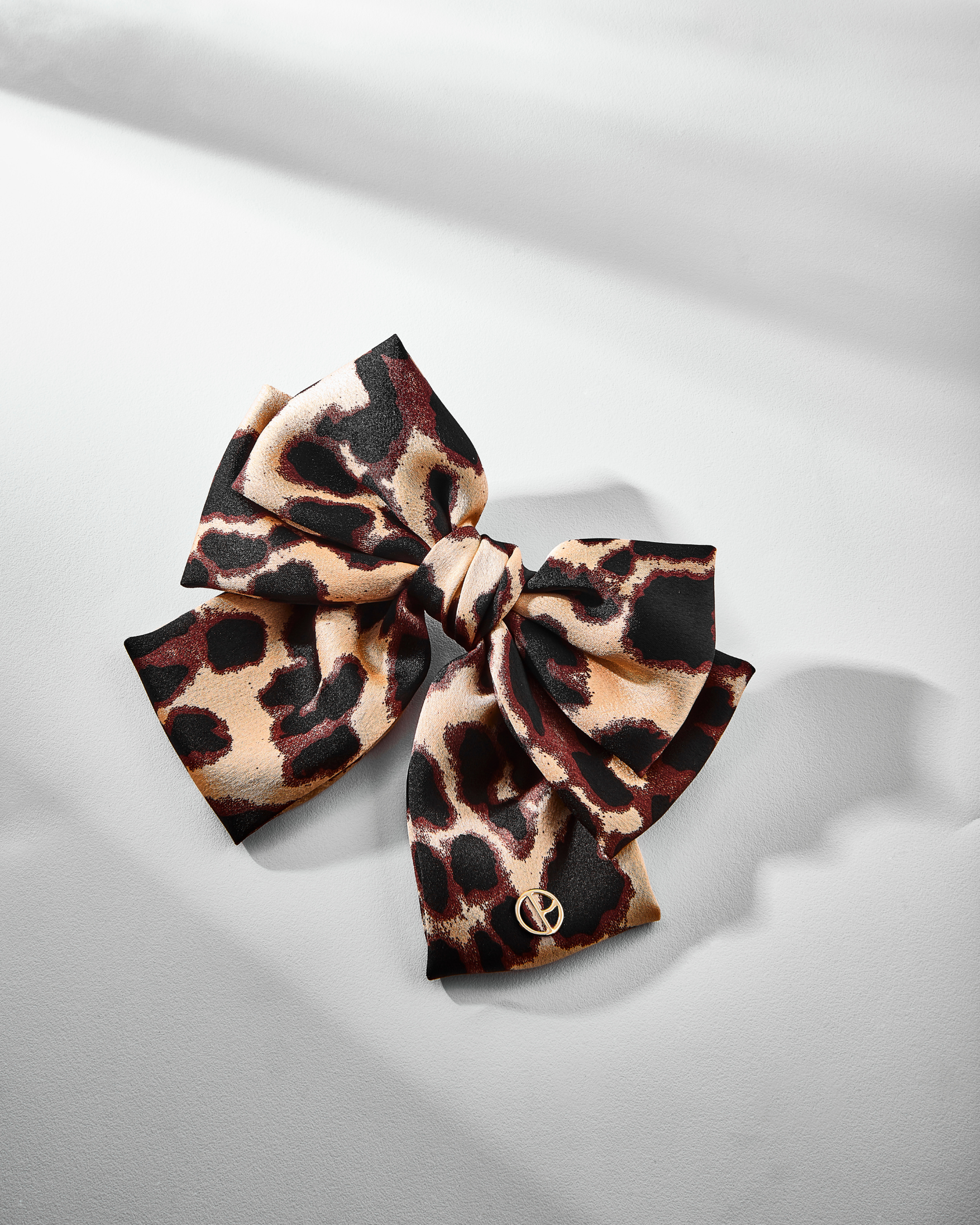 Laço Alika, design drapeado em animal print que simboliza laços de amizade eterna.