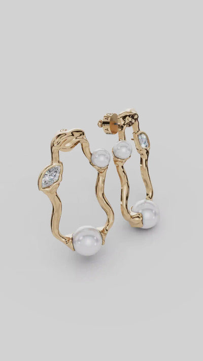 Brinco Gabrielle em tonalidade dourada, com pérolas, cristais austríacos e formas orgânicas esculturais. Uma joia sofisticada para eventos e produções elegantes.