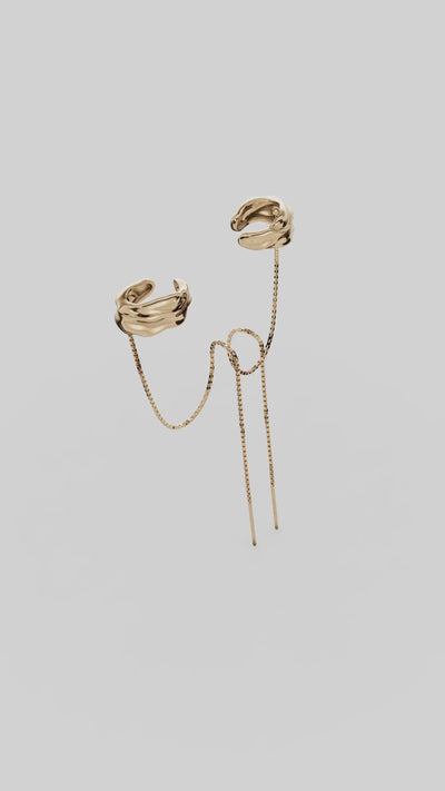 Piercing Frida em  dourado e prateado, com forma orgânica e correntes longas que acompanham o movimento. Uma joia statement, escultural e expressiva.