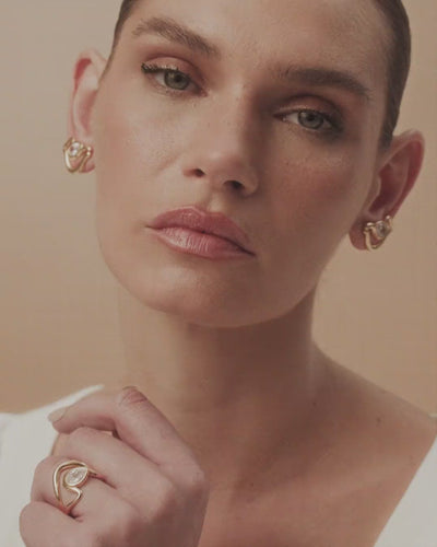 Brinco Audrey P dourado e prata, com cristal austríaco acolhido por curvas delicadas de beleza atemporal.